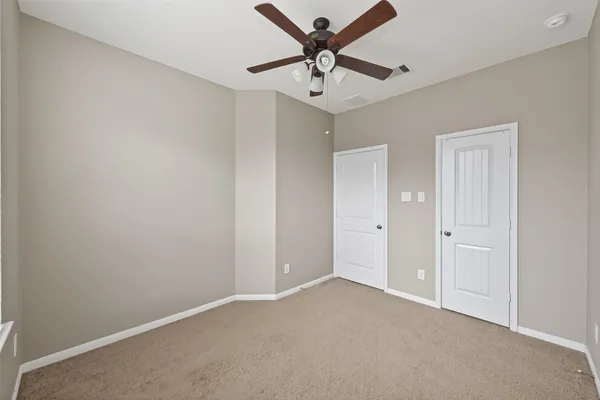 an empty room with a window and a fan