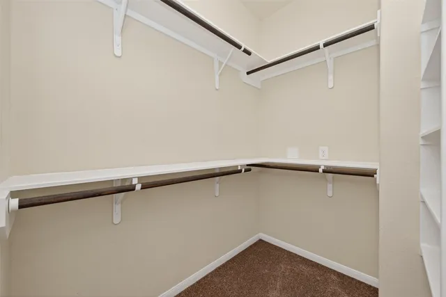 a view of a livingroom with a ceiling fan & cabinets
