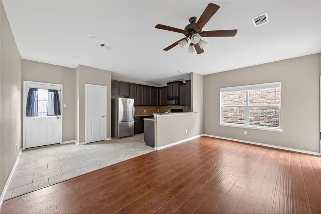 a view of a kitchen with a sink dishwasher cabinets and wooden floor
