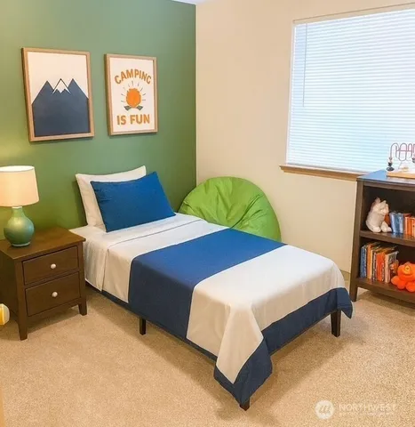 a bedroom with 2 bed and a painting on the wall