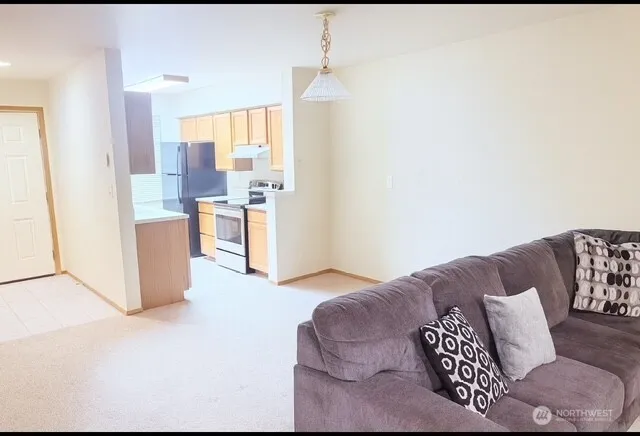 a living room with furniture and a kitchen