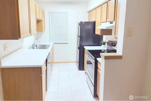 a kitchen with a sink a stove and a refrigerator