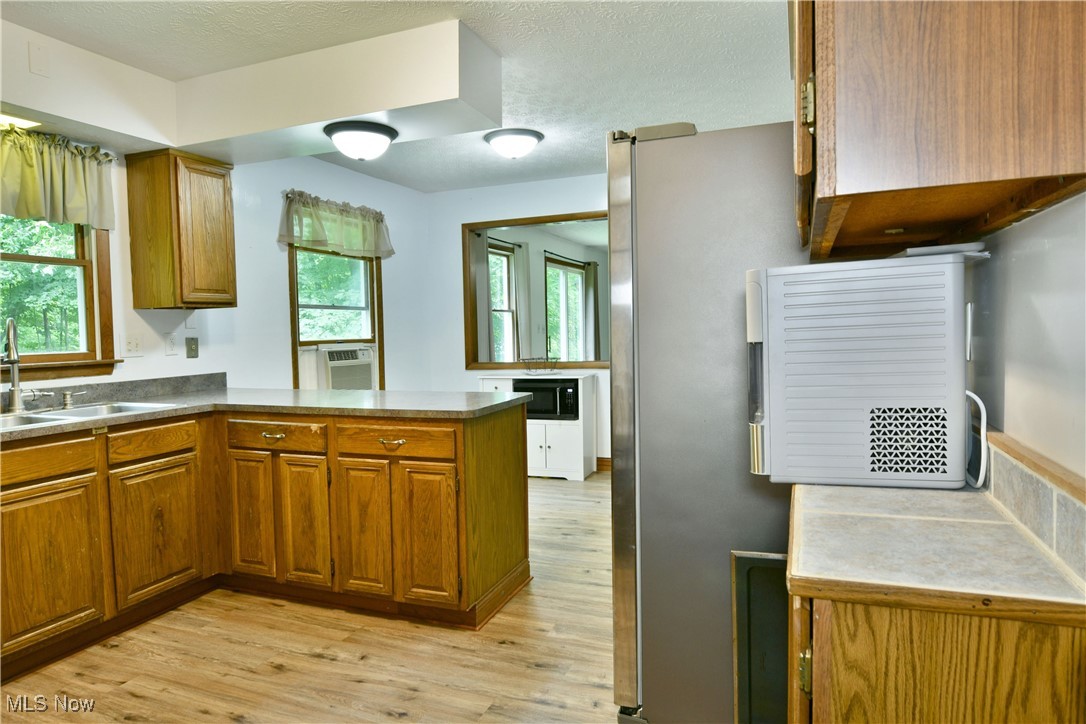 5531 Phillips Rice Road Cortland, OH 44410 - Photo 15 of 50 Kitchen featuring brown cabinets, a peninsula, and light wood-type flooring