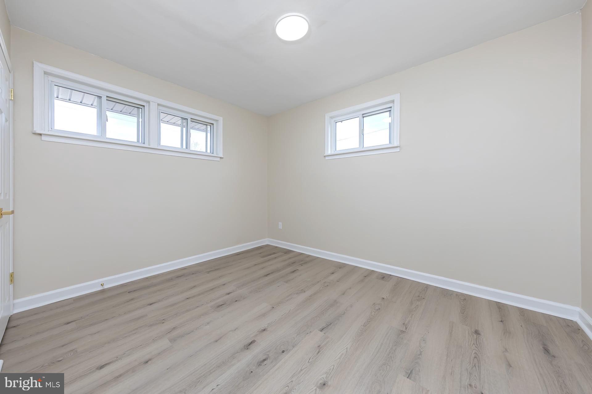 1117 Monmouth Road Deptford, NJ 08096 - Photo 15 of 18 an empty room with wooden floor and windows