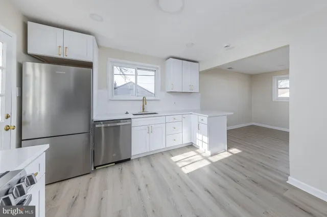 a kitchen with a refrigerator sink and cabinets