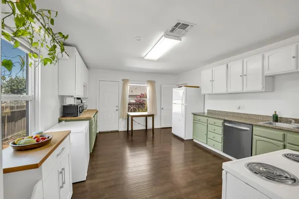 a kitchen with a sink a refrigerator and white cabinets
