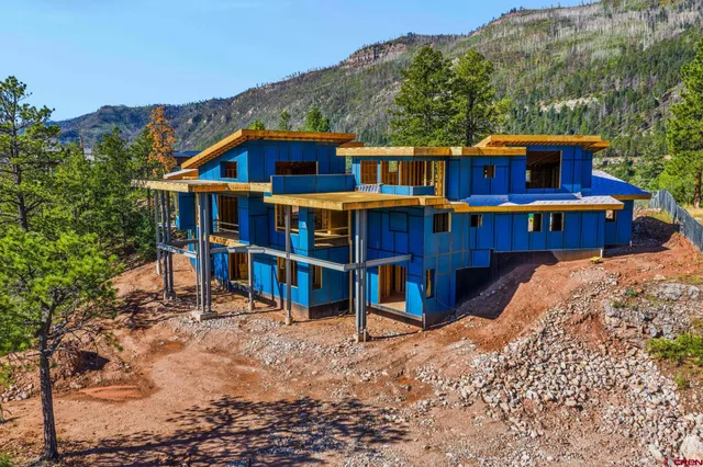 a view of a house with a large window and wooden fence