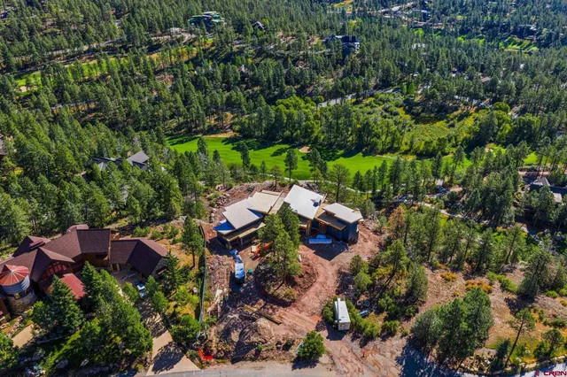an aerial view of a house with a yard and lake view