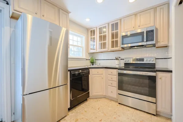 a kitchen with stainless steel appliances granite countertop a refrigerator stove and microwave