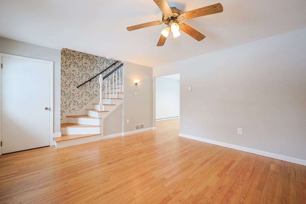 75 Sandy Pond Road, Unit 24 Ayer, MA 01432 - Photo 12 of 41 an empty room with wooden floor fan and windows