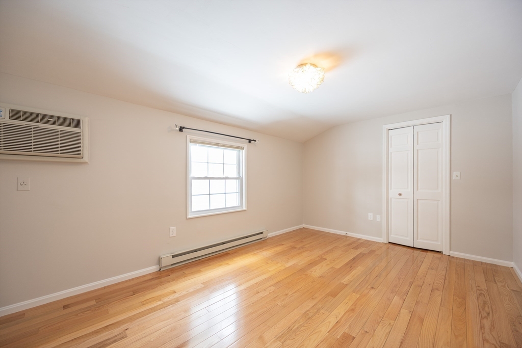 75 Sandy Pond Road, Unit 24 Ayer, MA 01432 - Photo 16 of 41 an empty room with wooden floor and windows