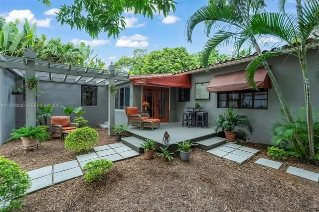 a view of a house with patio table and chairs