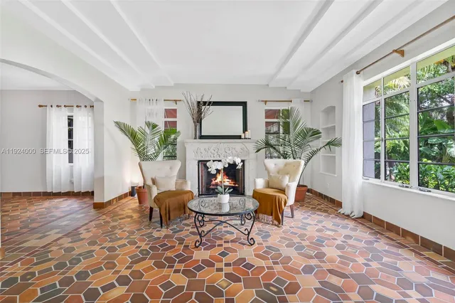 a living room with furniture a fireplace and a potted plant