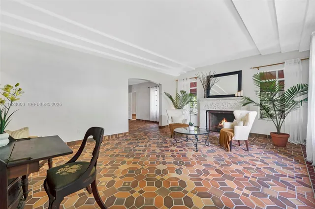 a living room with furniture a fireplace and a large window