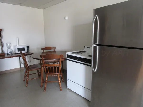 a kitchen with a refrigerator a table and chairs