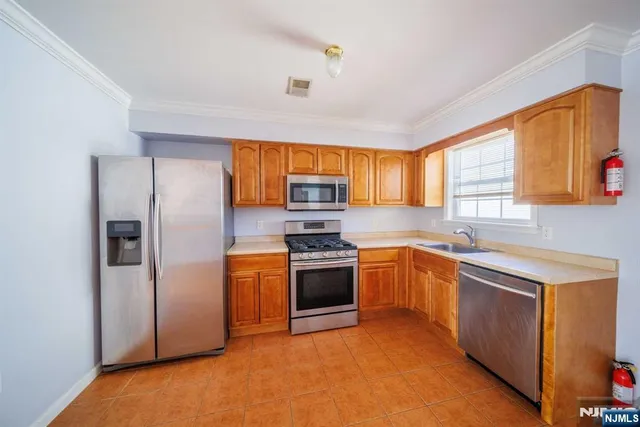 a kitchen with stainless steel appliances granite countertop a refrigerator a sink dishwasher stove and oven