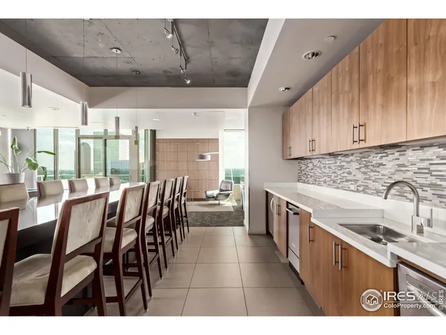 a kitchen with stainless steel appliances kitchen island granite countertop a table chairs sink and cabinets