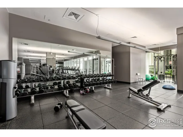 a room with gym equipment and large mirror