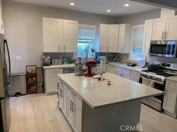 a kitchen with a sink a stove a refrigerator and cabinets