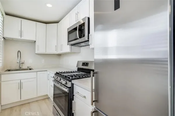 a kitchen with appliances a sink and cabinets