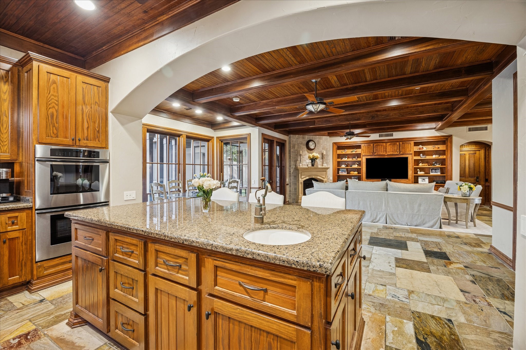 3715 Garnet Street Houston, TX 77005 - Photo 14 of 50 The kitchen flows seamlessly into the main living area. The wood-beamed ceilings and arched openings add architectural depth.