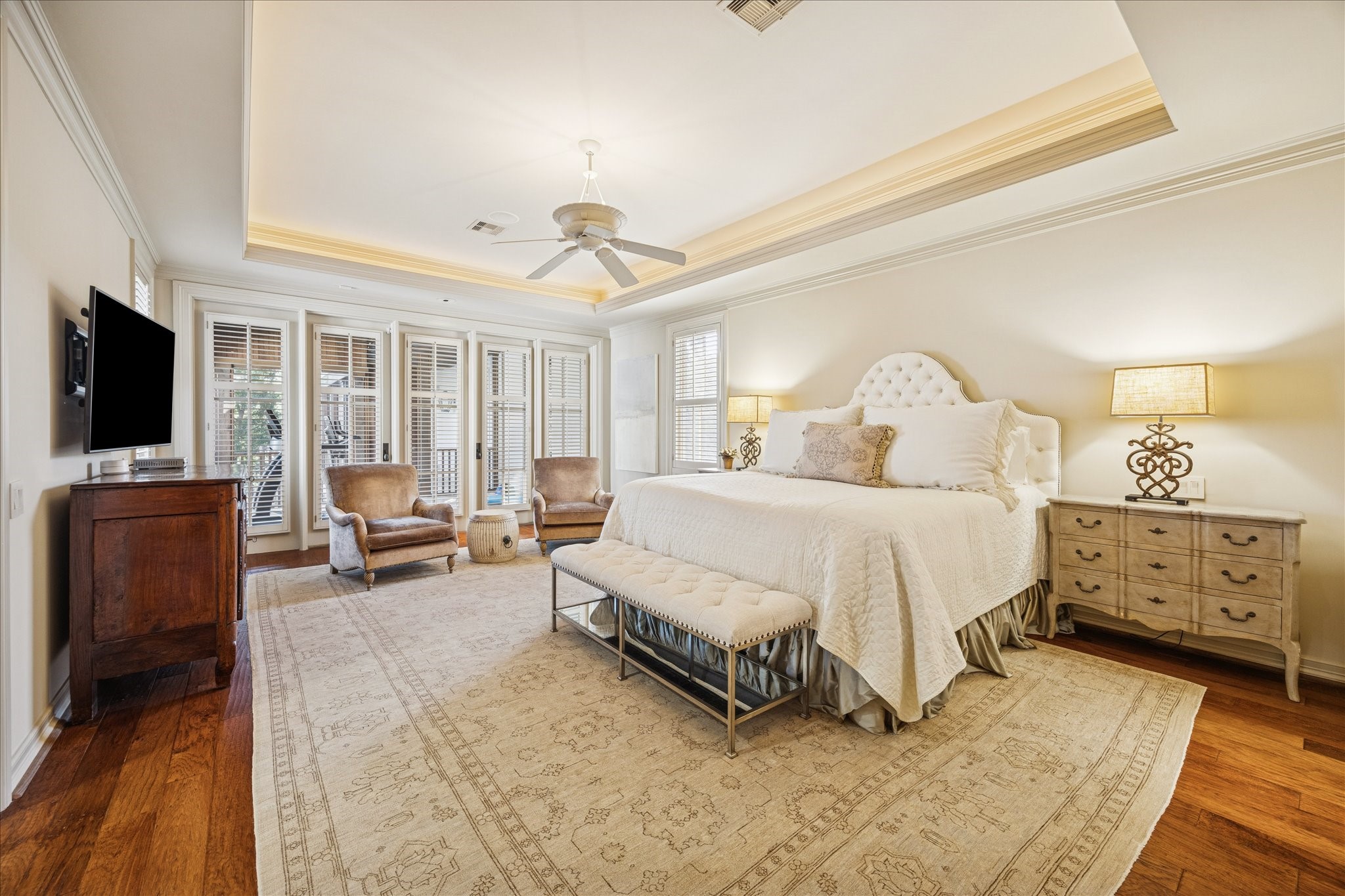 3715 Garnet Street Houston, TX 77005 - Photo 25 of 50 Luxurious retreat-style primary suite accented by a classic tray ceiling. The French Doors, featuring Plantation Shutters, lead to another covered, screened in porch overlooking the backyard.