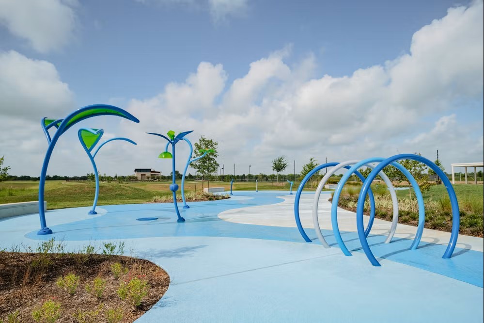 17439 Chester Valley Trail Hockley, TX 77447 - Photo 18 of 22 This photo showcases a modern splash pad in a community park, featuring playful water structures and a spacious, open design. It's ideal for families seeking outdoor recreational amenities in a neighborhood.