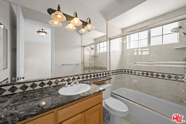 a bathroom with a sink a large mirror and a shower