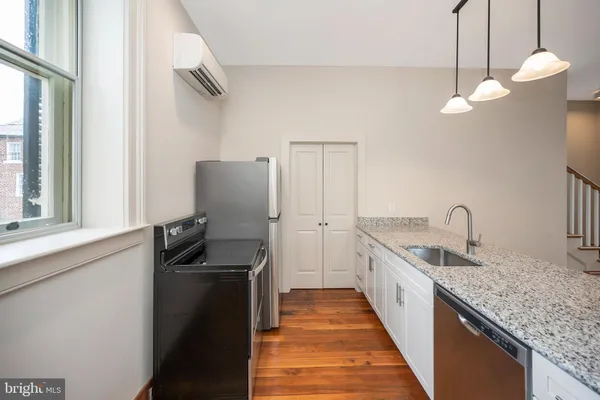a kitchen with sink stove and refrigerator