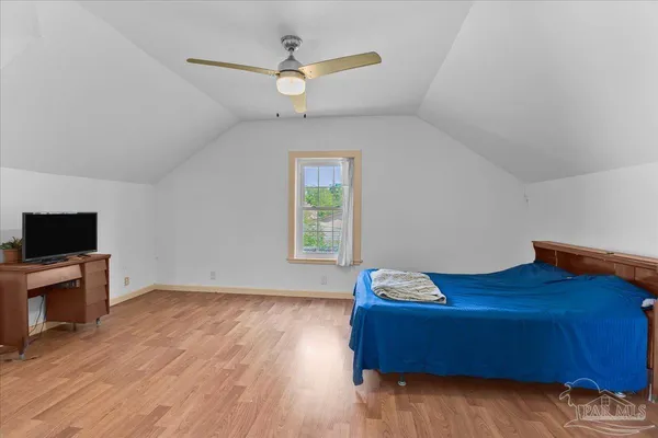 a bedroom with a bed a flat screen tv and a large window