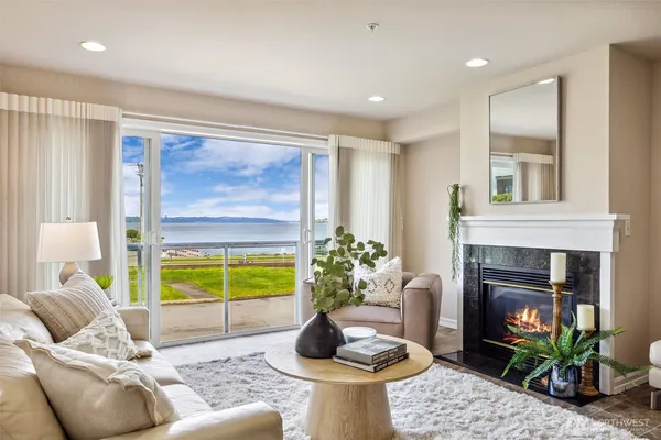a living room with furniture a fireplace and a floor to ceiling window