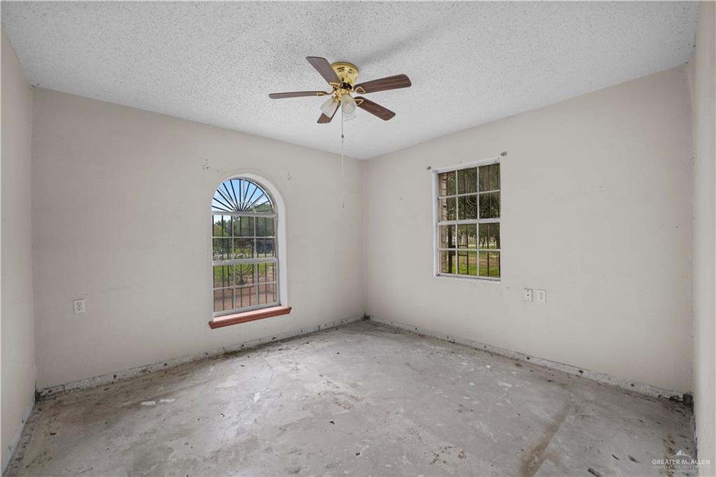 7708 Alberto Road Edinburg, TX 78542 - Photo 11 of 17 an empty room with windows and ceiling fan
