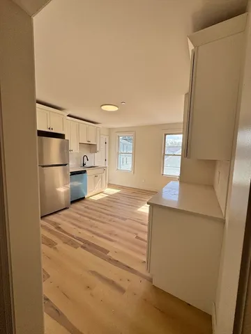 a room with a bed and a refrigerator