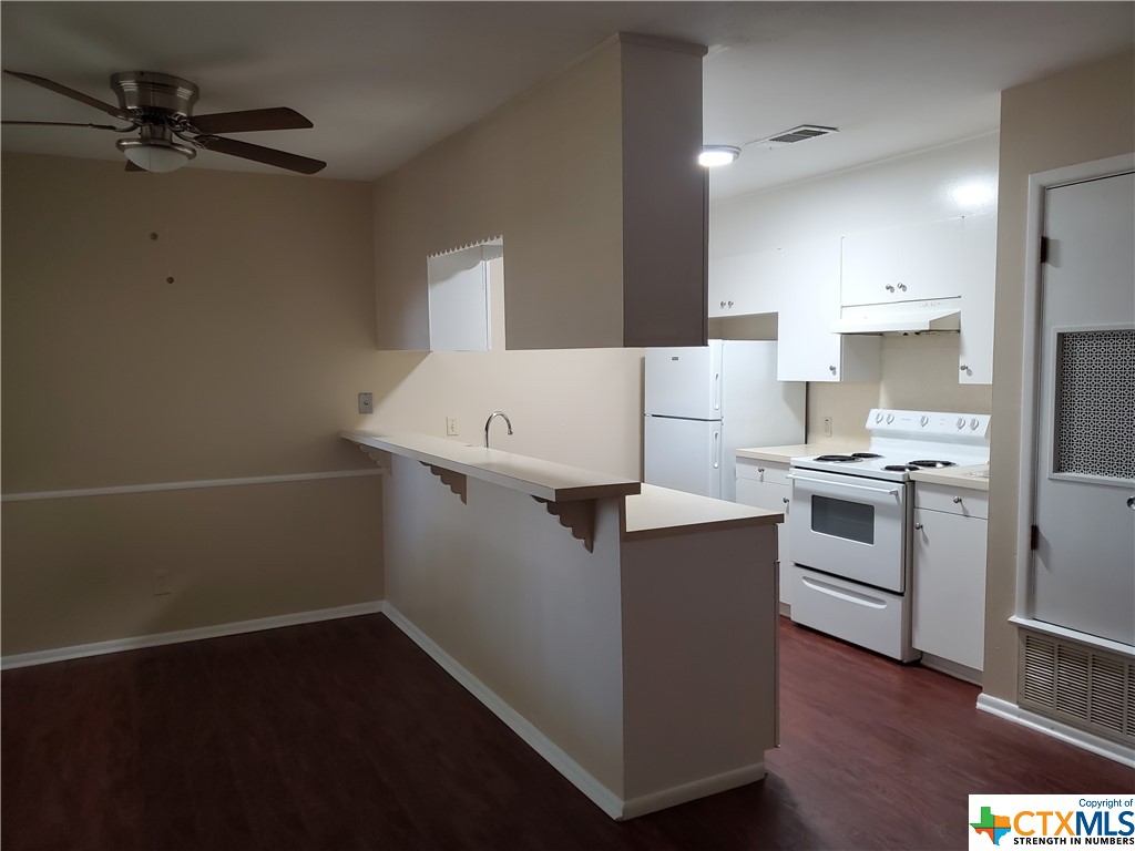 a kitchen with a cabinets and wooden floor