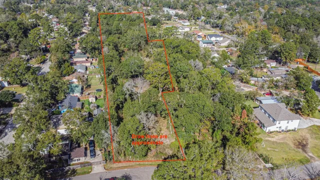 an aerial view of residential houses with outdoor space and trees