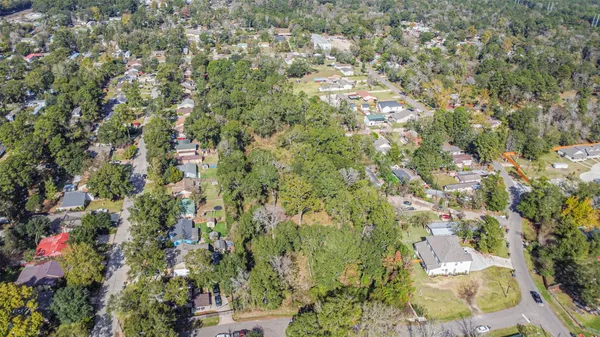 an aerial view of residential houses with outdoor space and trees