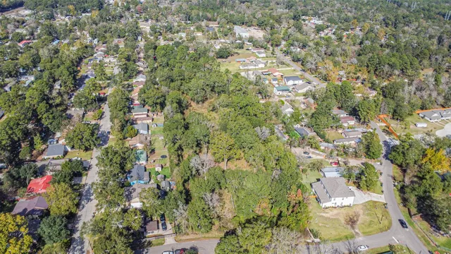 an aerial view of residential houses with outdoor space and trees