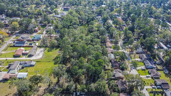 an aerial view of residential house with outdoor space and trees all around