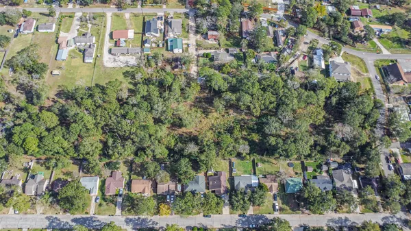 an aerial view of residential houses with outdoor space and trees