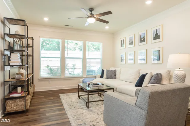 a living room with furniture and a large window with wooden floor