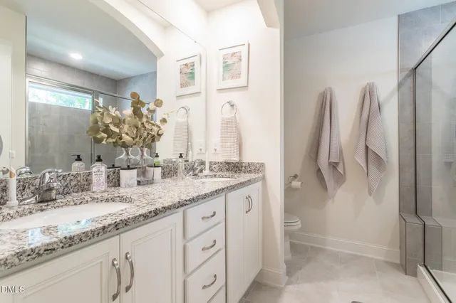 a bathroom with a double vanity sink a mirror and a shower