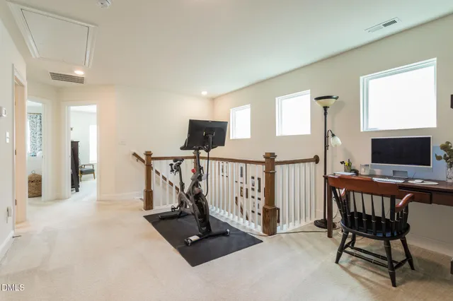 a living room with furniture a flat screen tv and a refrigerator