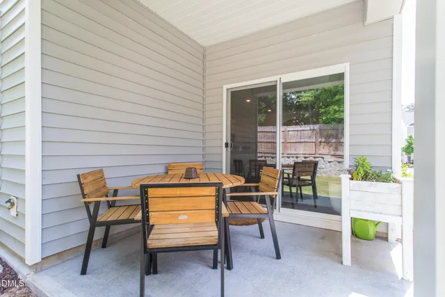 a backyard of a house with table and chairs