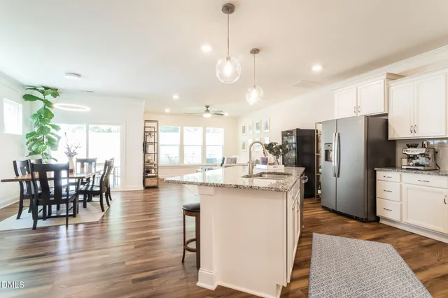 a kitchen with refrigerator and chairs
