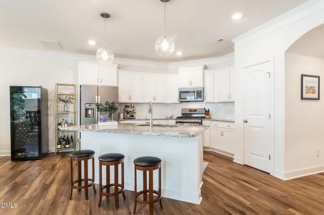 a kitchen with kitchen island granite countertop a center island a sink cabinets and stainless steel appliances