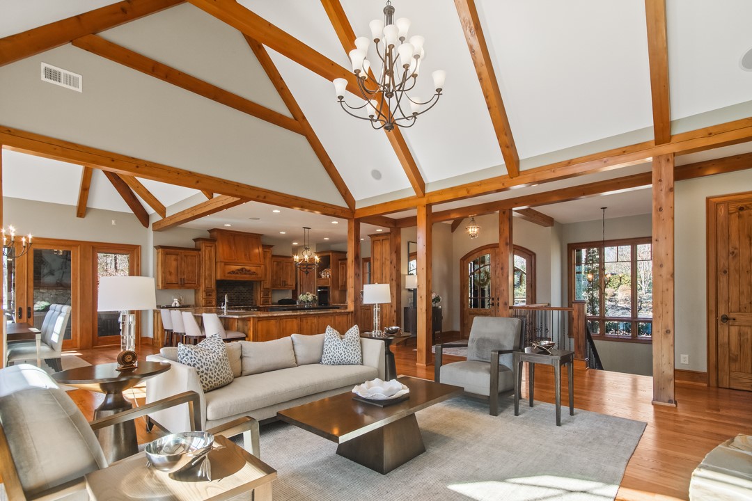 206 Feather Bell Lane Sunset, SC 29685 - Photo 15 of 50 A welcoming great room showcases soaring vaulted ceilings with exposed beams, rich hardwood floors, and an effortless flow into the kitchen—perfectly designed for relaxed gatherings and everyday living.