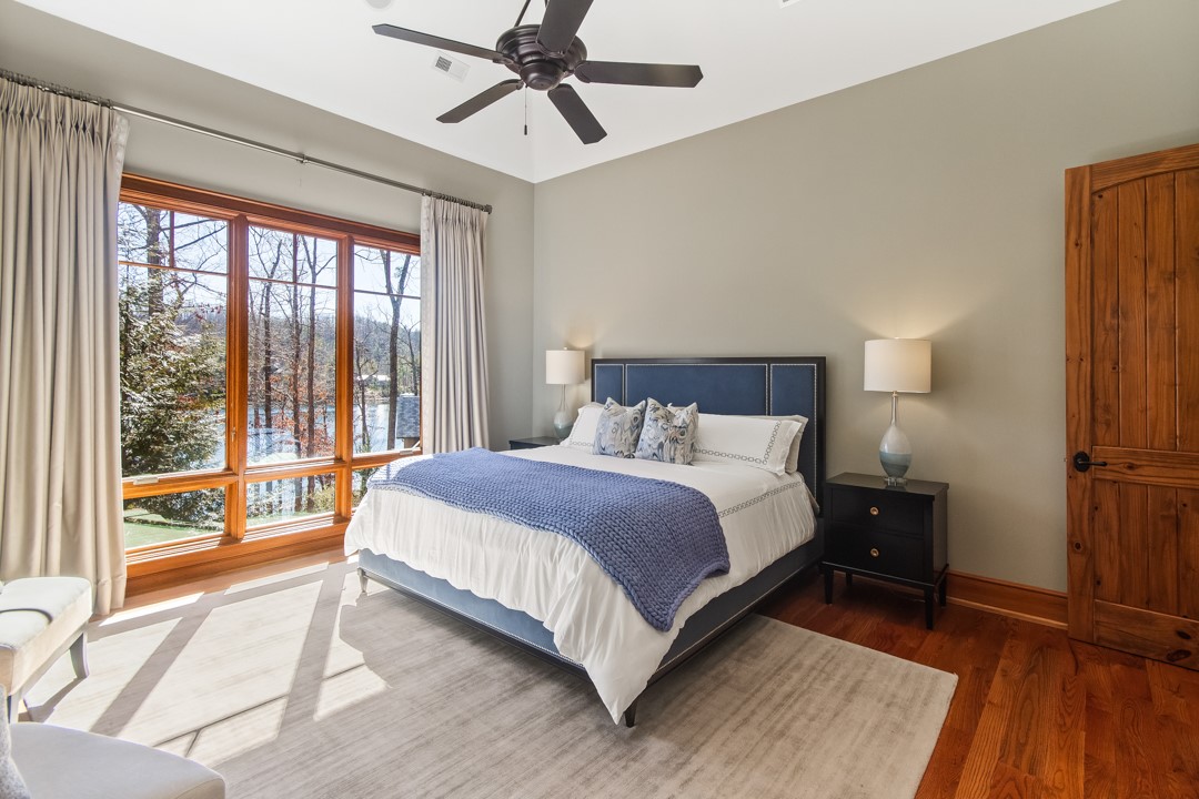 206 Feather Bell Lane Sunset, SC 29685 - Photo 20 of 50 This primary bedroom offers warm wood flooring and expansive windows providing serene water views.