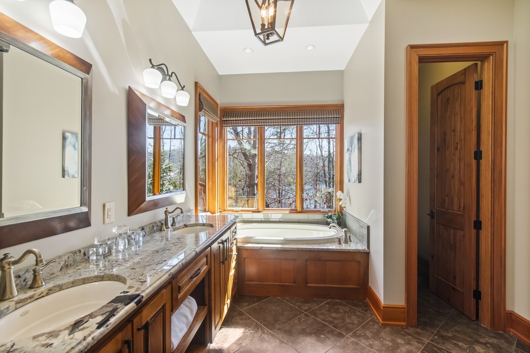206 Feather Bell Lane Sunset, SC 29685 - Photo 25 of 50 Luxurious bathroom with granite counters, dual vanities, a soaking tub, and a scenic water view.