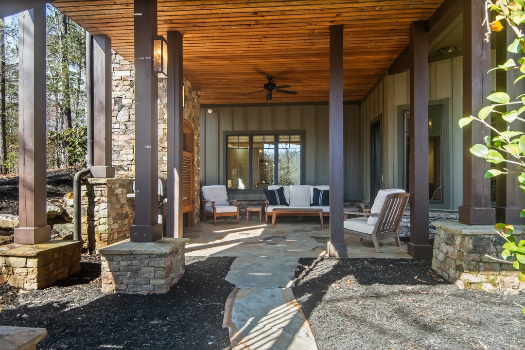 206 Feather Bell Lane Sunset, SC 29685 - Photo 38 of 50 This inviting porch offers comfortable lounging with a natural wood ceiling and stone accents.