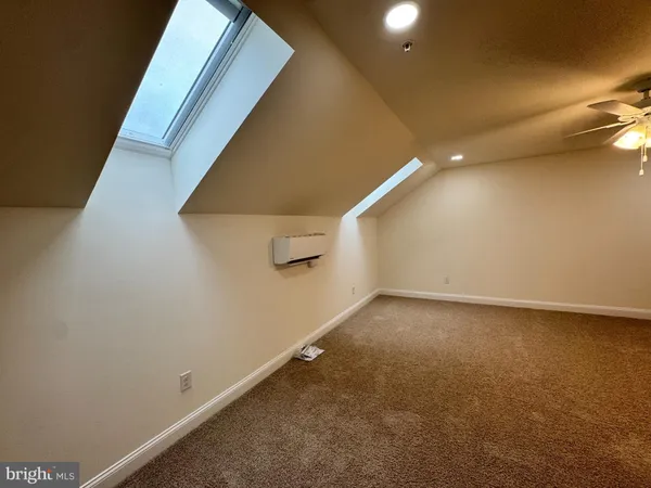 an empty room with a ceiling fan and bathroom